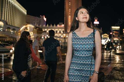 elegant young asian woman traveler walking at street shopping center mall in las vegas. night going out party lifestyle concept. happy beautiful girl tourist relax in modern nightlife city urban.