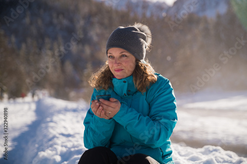 Woman taking a break from skiing and drinking hot tea photo