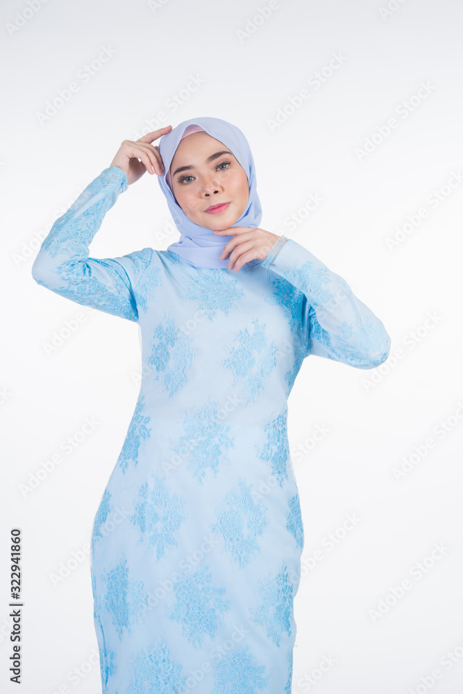 Beautiful Muslim female model wearing pastel blue modern kurung with hijab, a urban lifestyle apparel for Muslim women isolated on white background. Beauty and hijab fashion concept. Half length