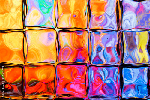 Abstract background of a colorful image distorted through a glass block wall