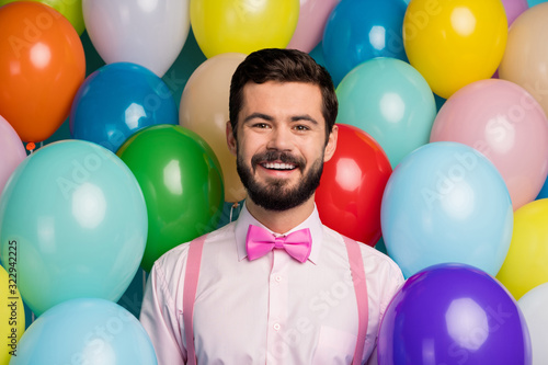 Photo of funny handsome gentleman guy surrounded colorful balloons arranging birthday party wear pink shirt bow tie suspenders on bright many balloons creative background © deagreez