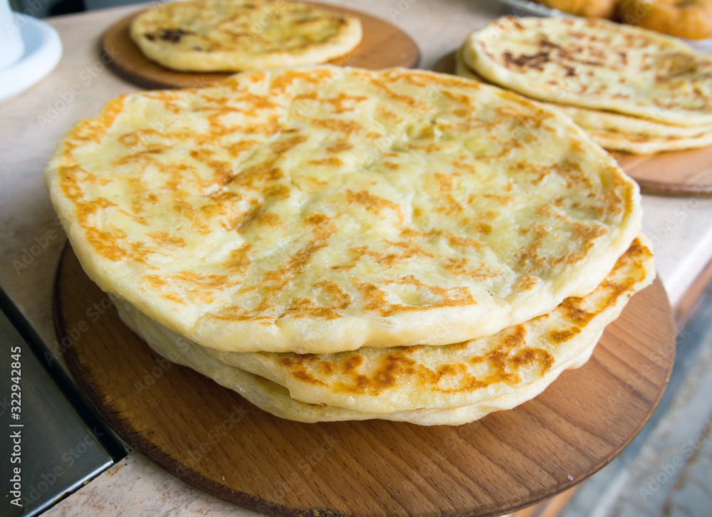 Ready-made Caucasian pancakes lie on a wooden dish Ready-made Caucasian pancakes lie on a wooden dish