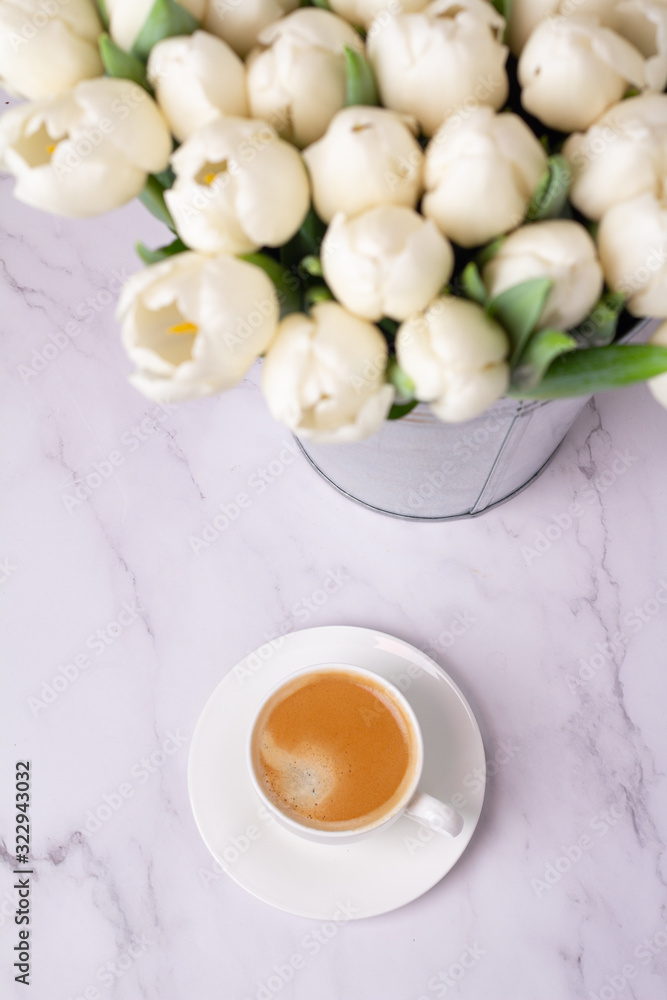 cup of coffee and a bouquet of white tulip in defocus closeup top view cup of coffee and a bouquet of white tulip in defocus closeup top view