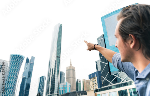 Man pointing at skyscrapers of modern cityscape.