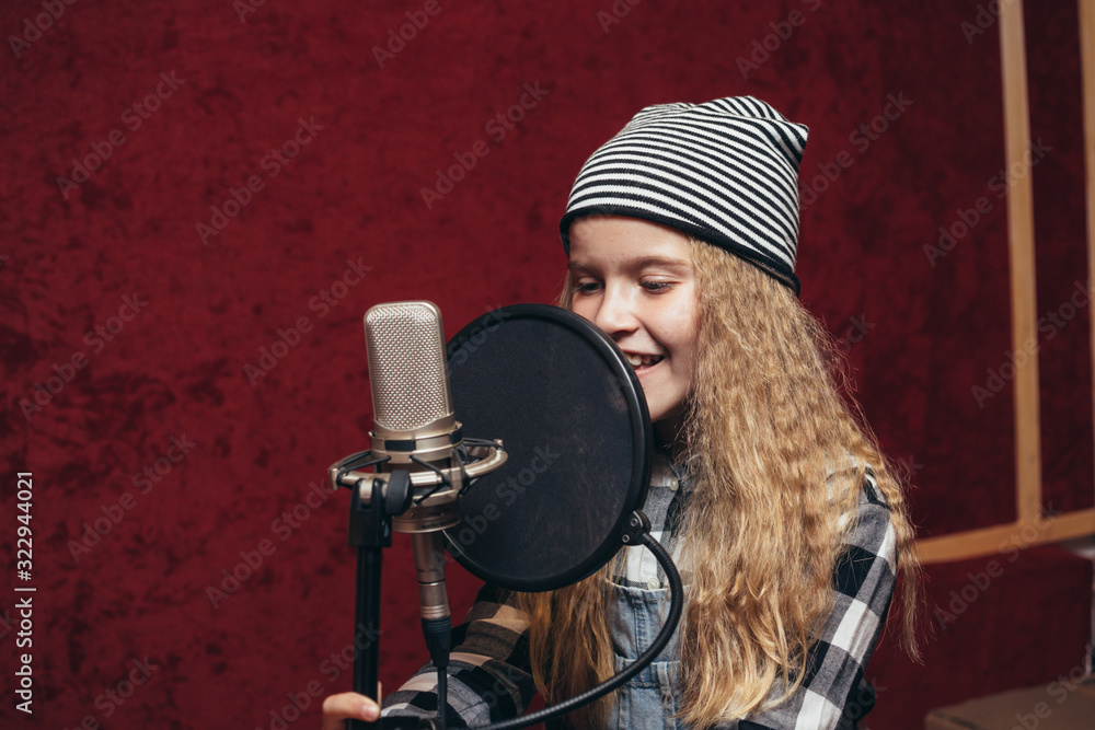 Fototapeta premium young girl singing in studio
