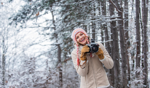 cold and beautiful weather. happy hiker girl retro camera. professional photographer winter landscape. woman hold photo camera. make photo shot of snowy winter nature. Lost in thoughts