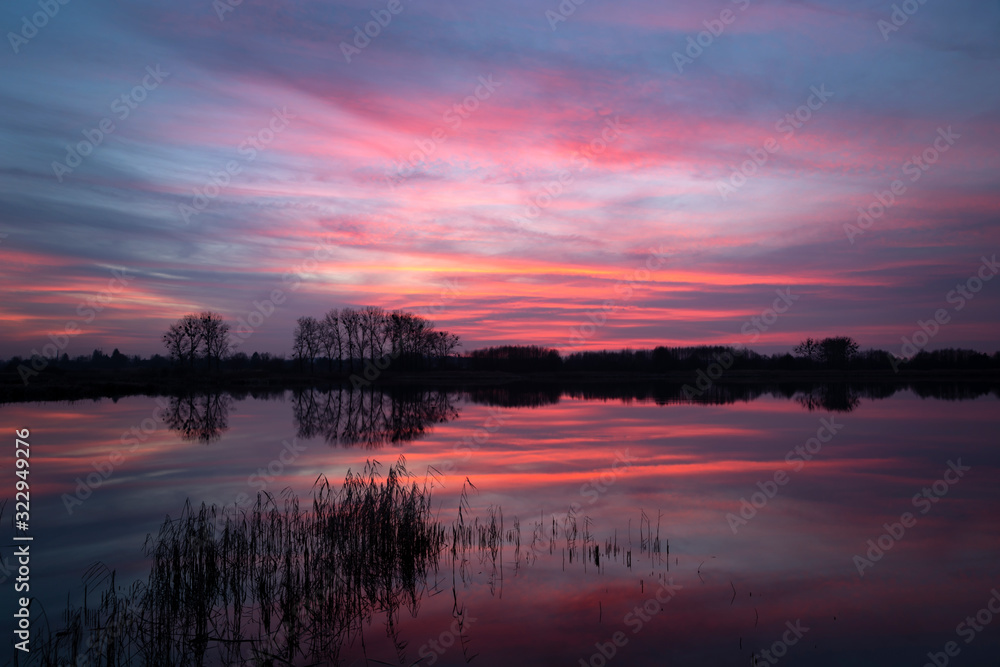 Colorful clouds reflecting on the lake after sunset, beauty evening view
