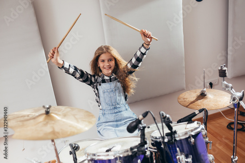Photo young girl playing drums in music studio