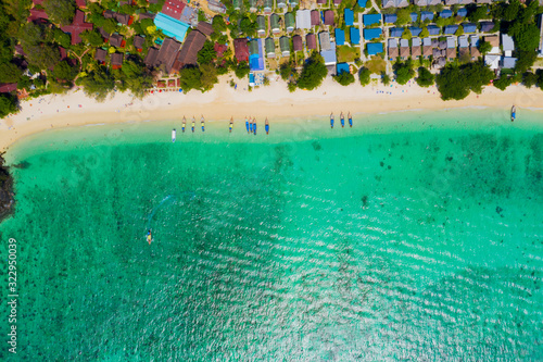 View from above, stunning aerial view of a beautiful tropical beach with white sand and turquoise clear water, long-tail boat and people sunbathing,Long beach, Phi Phi Thailand.