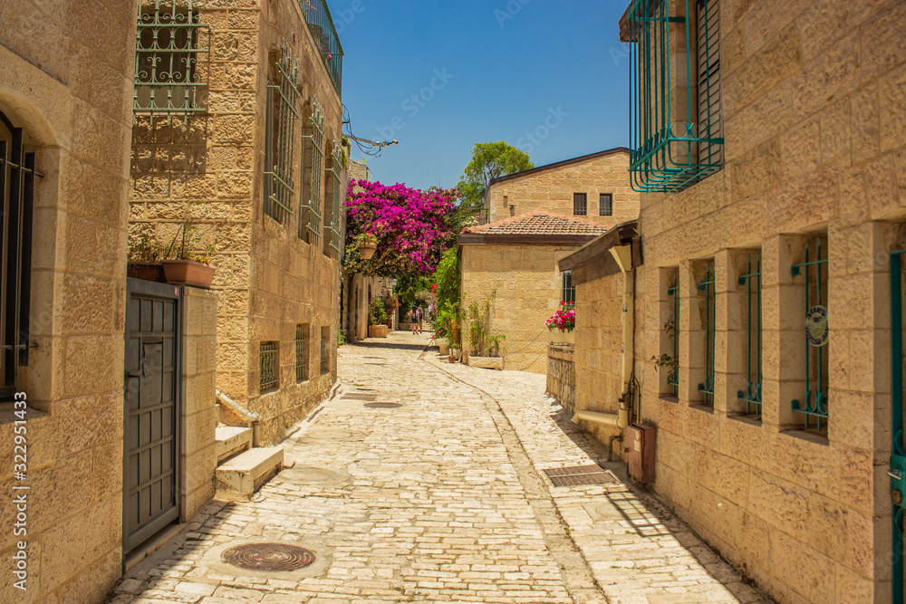 Jerusalem Israeli capital ancient city street stone paved walk side alley between living building in summer bright sunny day time