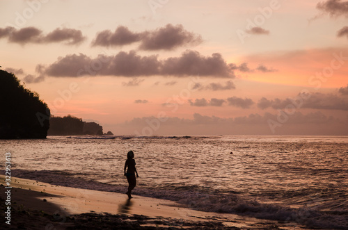 A woman walks into the sea during the sunset in Bali © Javi Sánchez
