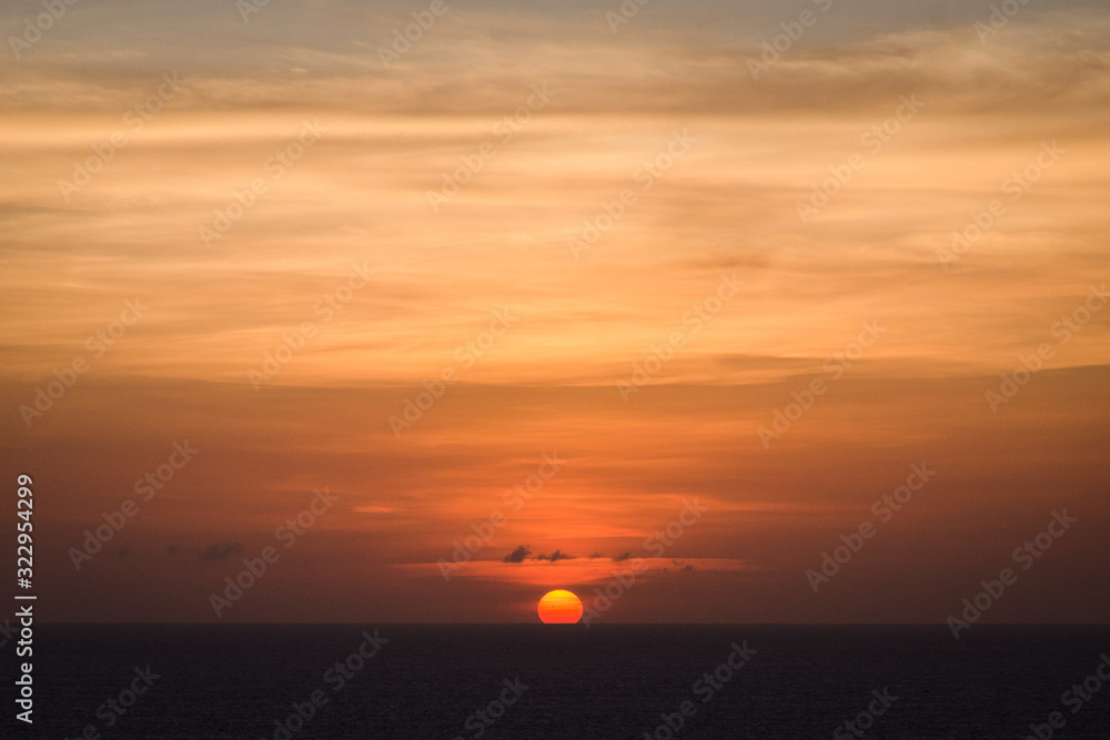 Sun setting over the sea in Bali with an orange sky