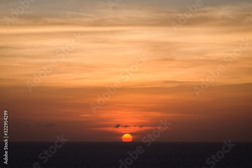 Sun setting over the sea in Bali with an orange sky