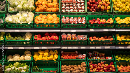 Various vegetables tomatoes, cucumbers, cabbage are sold at vegetable shop. Vegetables lie on shelf in grocery store.