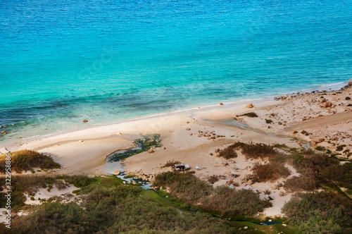 Top view from a sand dune on the coast of the Indian Ocean. exotic beautiful deserted island with a baked dune and views of the emerald coast. Campground on the shore. Socotra Yemen.