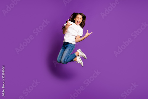 Full length body size view of nice attractive crazy glad cheerful cheery naughty wavy-haired girl jumping showing horn sign isolated on bright vivid shine vibrant purple violet lilac color background