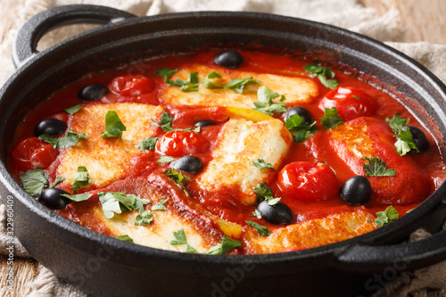 Cyprus food baked Halloumi with tomatoes, peppers, olives in a spicy sauce close-up in a pan. horizontal © FomaA