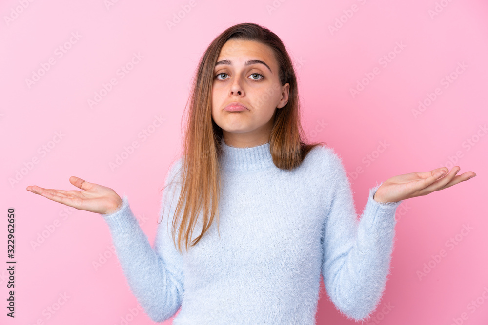 Teenager girl with blue sweater over isolated pink background having doubts with confuse face expression Teenager girl with blue sweater over isolated pink background having doubts with confuse face expression