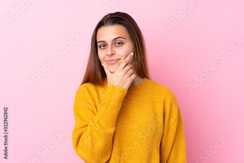Teenager girl with yellow sweater over isolated pink background thinking © luismolinero