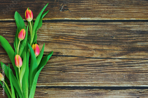 Flat view of tulips on wooden background