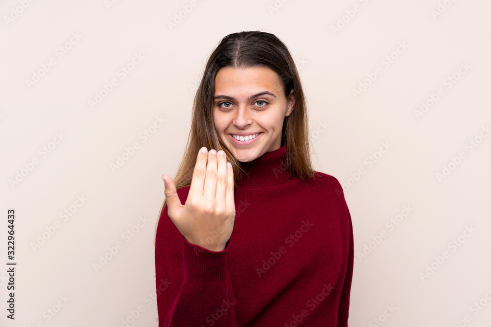 Teenager girl over isolated background inviting to come Teenager girl over isolated background inviting to come