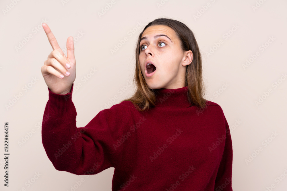 Teenager girl over isolated background pointing away Teenager girl over isolated background pointing away