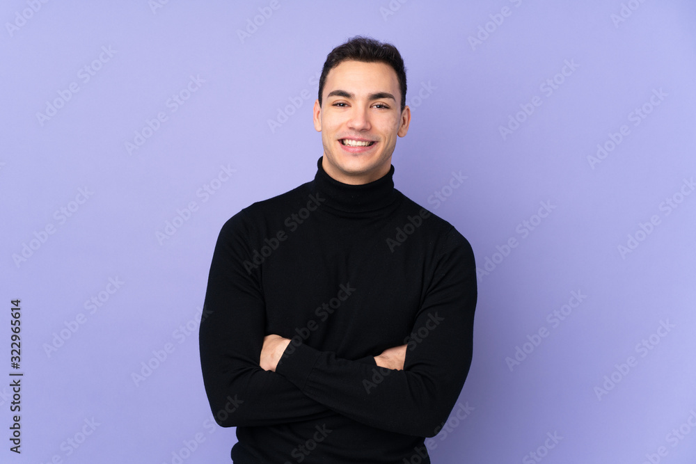 Young caucasian handsome man with turtleneck sweater isolated on purple background keeping the arms crossed in frontal position Young caucasian handsome man with turtleneck sweater isolated on purple background keeping the arms crossed in frontal position