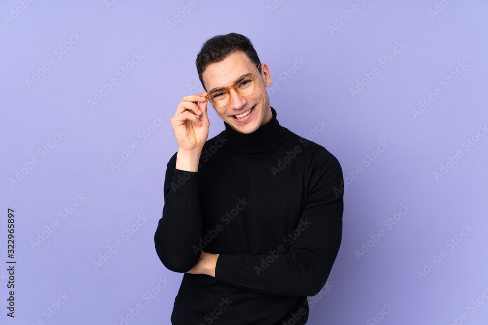 Young caucasian handsome man with turtleneck sweater isolated on purple background with glasses and happy Young caucasian handsome man with turtleneck sweater isolated on purple background with glasses and happy