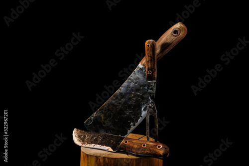 Rustic butcher meat knife, cleaver and fork on black background