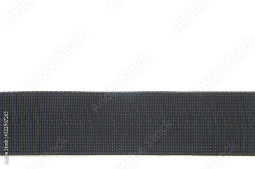 Wide black textile belt. Nothing extra. Belt made of fabric on a white isolated background. The abstraction is interesting. The horizontal location.