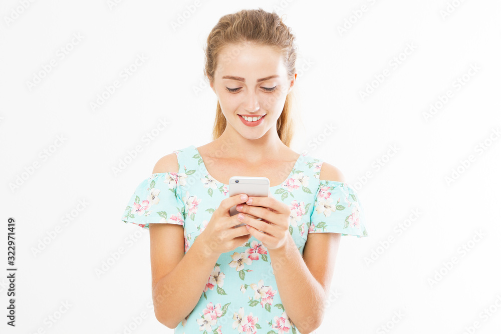 Young girl reads something interesting on her mobile phone on a white background copy space. Young girl reads something interesting on her mobile phone on a white background copy space.