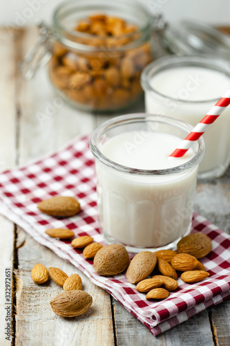 Fresh organic vegan almond milk. Alternative source of protein for vegetarians. Raw almonds as ingredients, peeled and unpeeled. Concept of healthy lifestyle. Closeup, white background.