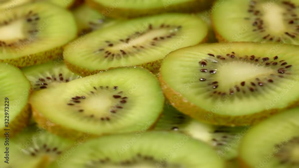 Sliced kiwi goodbye on a wooden board. Fresh pieces of kiwi revolve in a circle on a wooden board. Sliced kiwi goodbye on a wooden board. Fresh pieces of kiwi revolve in a circle on a wooden board.
