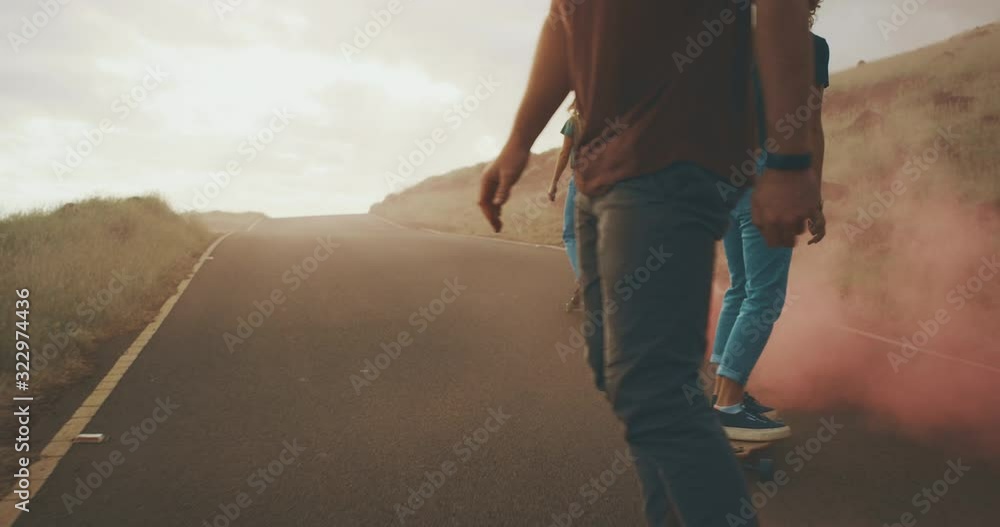 Three young adventurous friends skateboarding together with colorful pink smoke trails, stylish millennials riding skateboards with funky fun pink smoke Three young adventurous friends skateboarding together with colorful pink smoke trails, stylish millennials riding skateboards with funky fun pink smoke