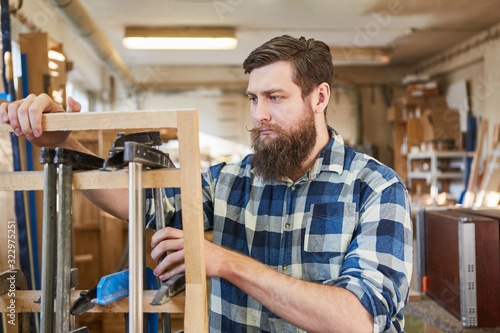 Hipster Schreiner sortiert Schraubzwingen photo