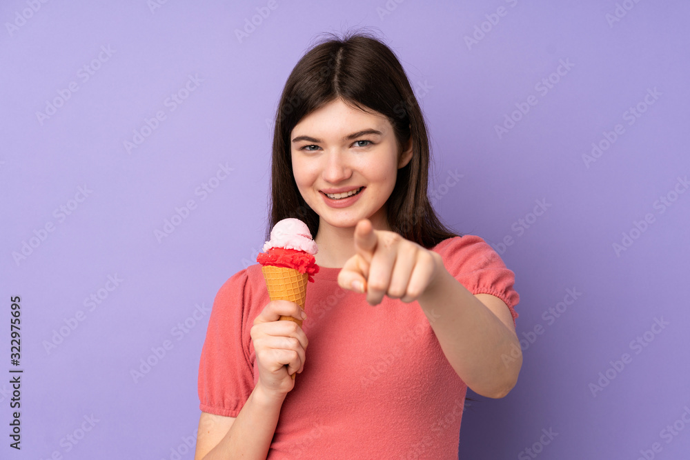 Young Ukrainian teenager girl holding a cornet ice cream over isolated purple background points finger at you with a confident expression Young Ukrainian teenager girl holding a cornet ice cream over isolated purple background points finger at you with a confident expression