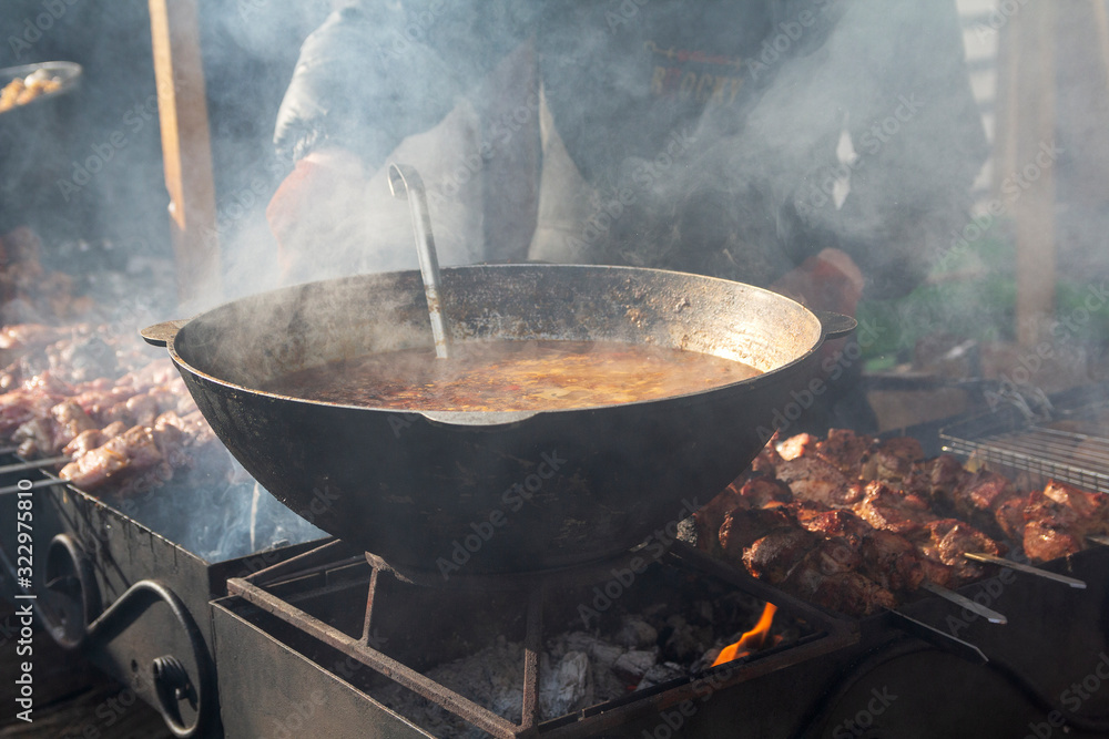 Metal pot over a fire on the street food festival Metal pot over a fire on the street food festival
