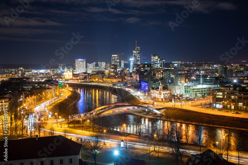 Vilnius, Lithuania, Europe, night scenic aerial panorama of modern business financial district architecture buildings with Neris river and bridge 