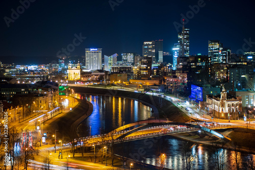 Vilnius, Lithuania, Europe, night scenic aerial panorama of modern business financial district architecture buildings with Neris river and bridge 