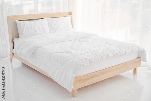Relaxation concept, interior decoration, comfort and bedding - white bed with white pajamas photo