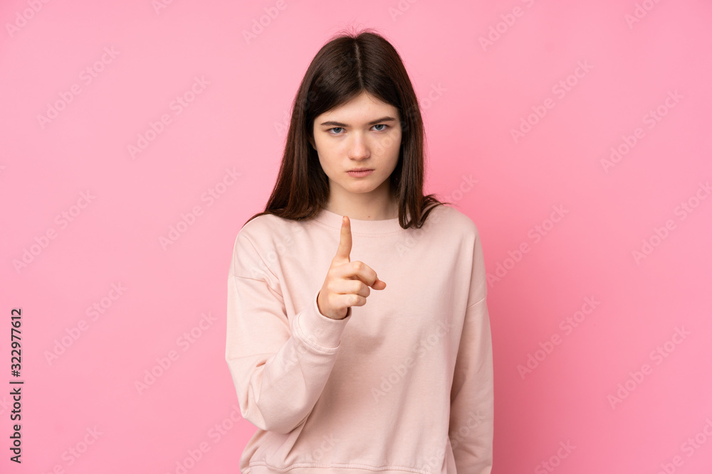 Young Ukrainian teenager girl over isolated pink background frustrated and pointing to the front Young Ukrainian teenager girl over isolated pink background frustrated and pointing to the front