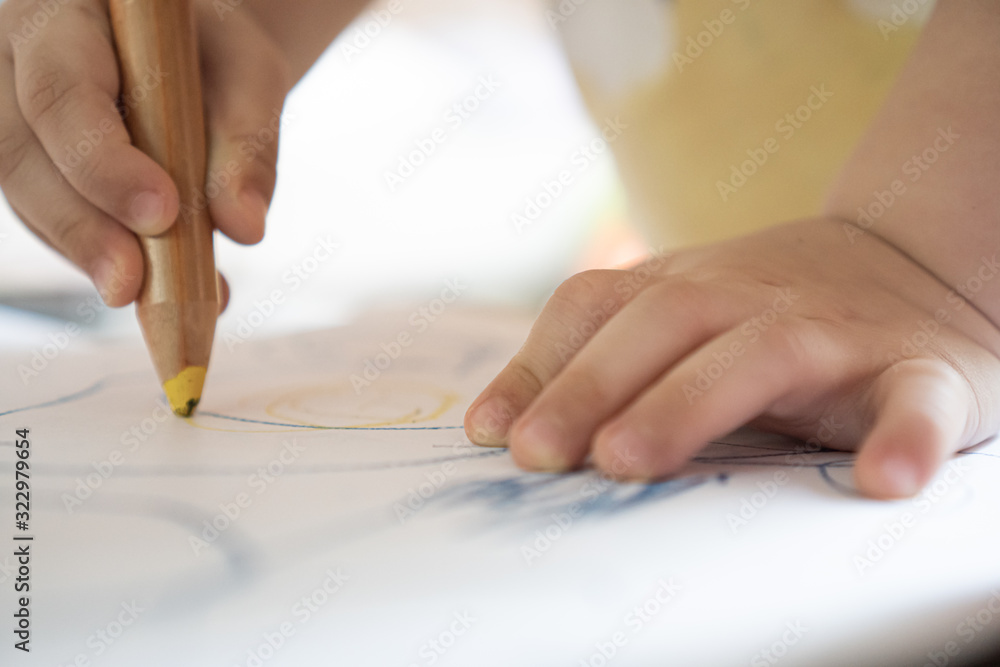 Close up hand of 2year kid use color pencil draw line on paper. Concept of art for children learning . Education and imagination Close up hand of 2year kid use color pencil draw line on paper. Concept of art for children learning . Education and imagination