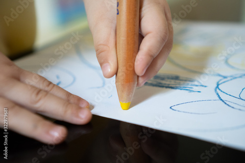 Close up hand of 2year kid use color pencil draw line on paper. Concept of art for children learning . Education and  imagination photo