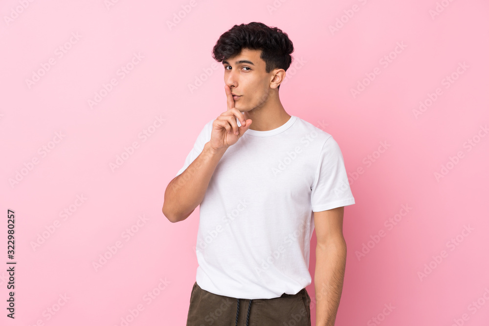 Young Argentinian man over isolated pink background doing silence gesture Young Argentinian man over isolated pink background doing silence gesture