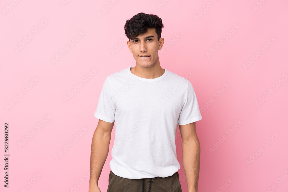 Young Argentinian man over isolated pink background having doubts and with confuse face expression Young Argentinian man over isolated pink background having doubts and with confuse face expression