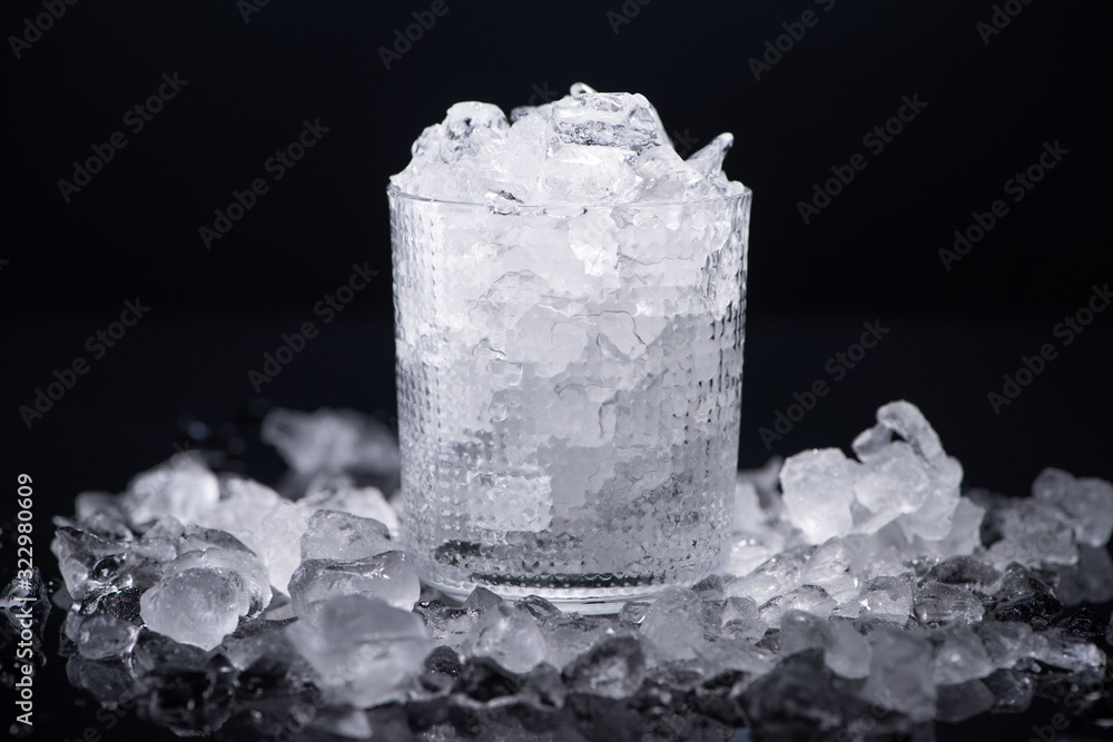 transparent glass filled with smashed ice isolated on black