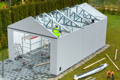 Installation of a new garage with metal elements in the garden photo