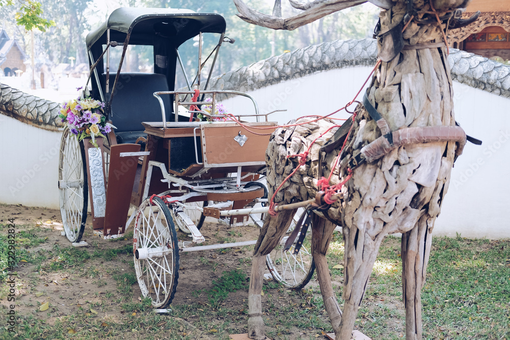 old vintage asian tricycle & wooden deer decorating in park