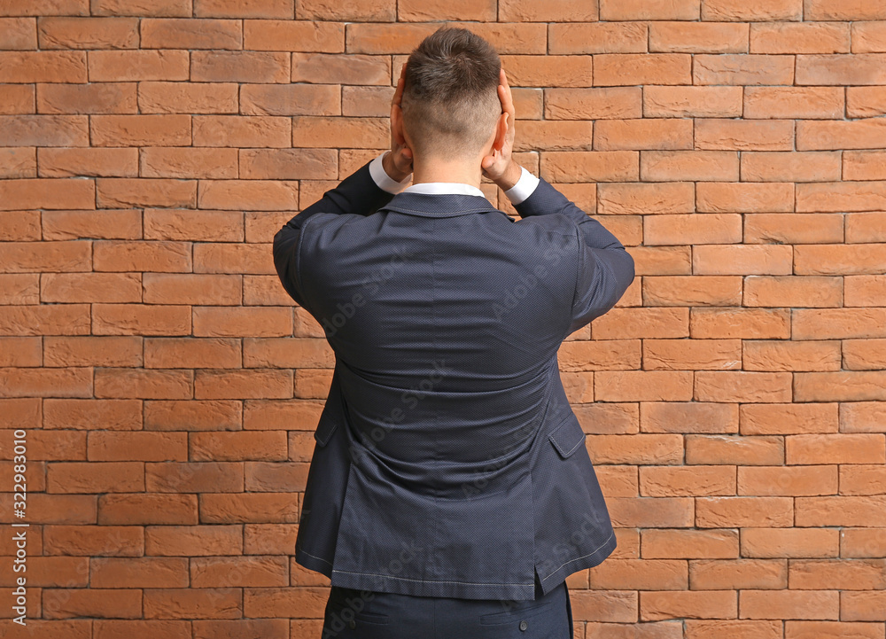 Stressed businessman on brick background. Concept of choice Stressed businessman on brick background. Concept of choice