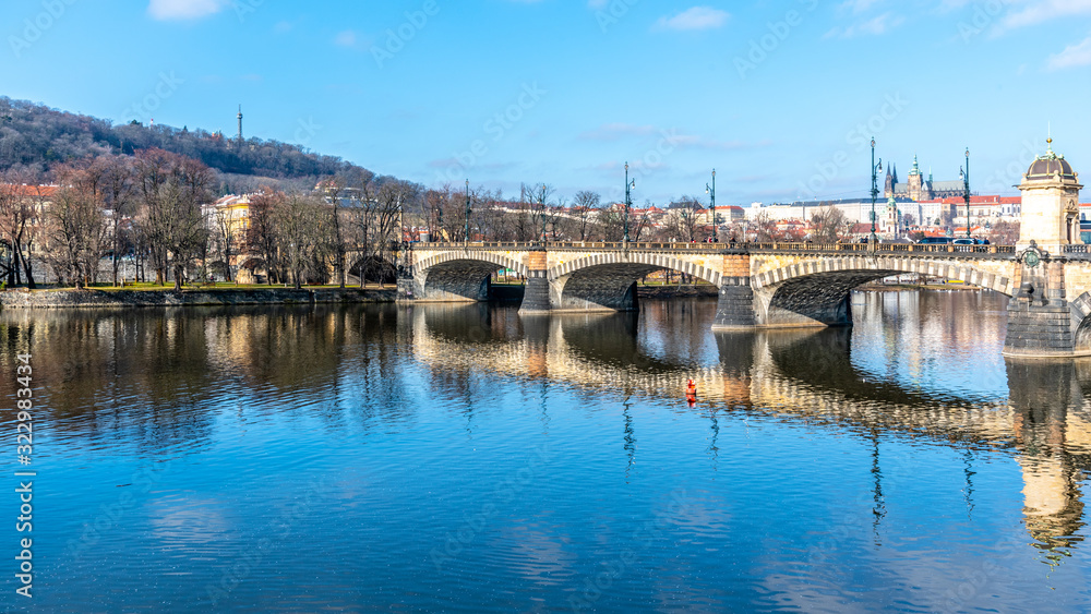 Legion Bridge, Czech: Most legii, reflected in Vltava River with Prague Castle and Petrin Hill on background. Clear sunny winter day in Prague, Czech Republic